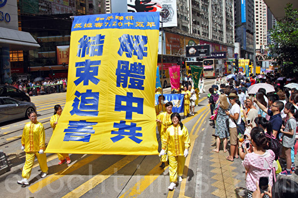 2014年7月19日，逾九百名法輪功學員在香港港島區舉行7.20十五周年反迫害集會遊行，呼籲各界制止中共迫害法輪功。隊伍從北角英皇道出發，途徑多個鬧市區抵達政府總部，吸引眾多中港民眾和遊客駐足觀看。（潘在殊／大紀元）