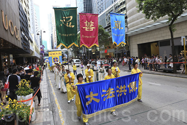 走過15年反迫害歷程，香港法輪功學員一連兩天舉行盛大遊行集會，呼籲「解體中共、結束迫害」。7月20日（星期天）繼續在九龍市中心舉行盛大遊行，呼籲解體中共、結束迫害和法辦元兇。 （余鋼/大紀元）