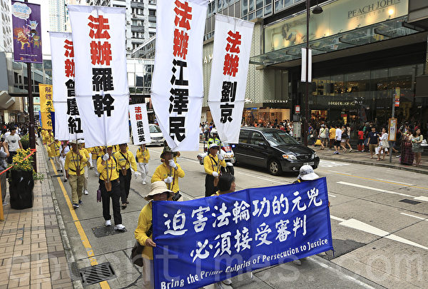 走過15年反迫害歷程，香港法輪功學員一連兩天舉行盛大遊行集會，呼籲「解體中共、結束迫害」。7月20日（星期天）繼續在九龍市中心舉行盛大遊行，呼籲解體中共、結束迫害和法辦元兇。 （余鋼/大紀元）