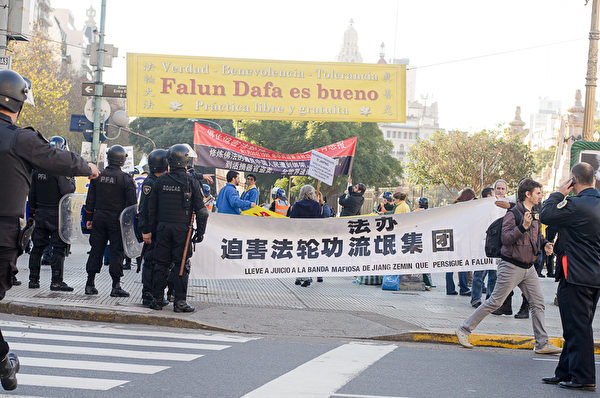 阿根廷警方在現場保護請願、舉橫幅的法輪功學員。（Daniel Musa/大紀元）