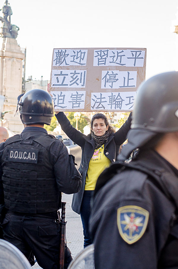 阿根廷警方在國會外現場保護請願、舉橫幅的法輪功學員。（Daniel Musa/大紀元）