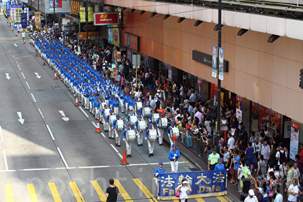 香港法輪功學員10月1日舉行國殤日遊行，8百多人的遊行隊伍途徑多個鬧市區，吸引不少市民駐足觀看，有參與太陽傘學運的大學生高喊法輪大法好，也有大陸遊客表示支持法輪功學員的信仰。（潘在殊/大紀元）
