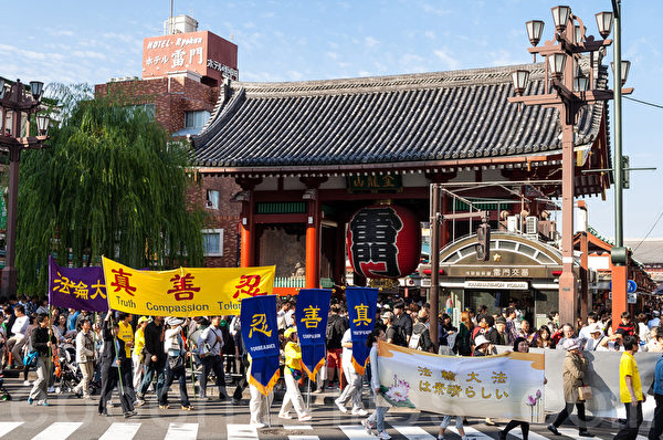 10月25日，来自日本各地的部分法轮功学员约300多人在东京举行反迫害游行，有来自中国大陆的游客了解到中共邪恶本质后当场表示退出中共的党、团、队组织。（游沛然/大纪元）