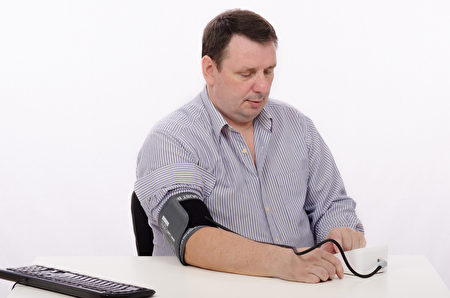 Middle aged man with blood pressure machine