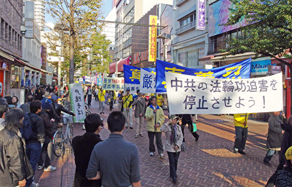 11月23日，來自日本各地的部份法輪功學員在橫濱市舉行紀念《九評》傳播10週年遊行，並呼籲共同制止中共迫害法輪功的罪行。（張本真/大紀元）