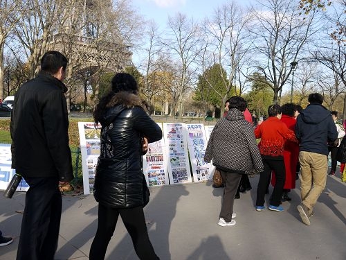 成群結隊的中國遊客路過巴黎鐵塔下的法輪功真相點。（明慧網）