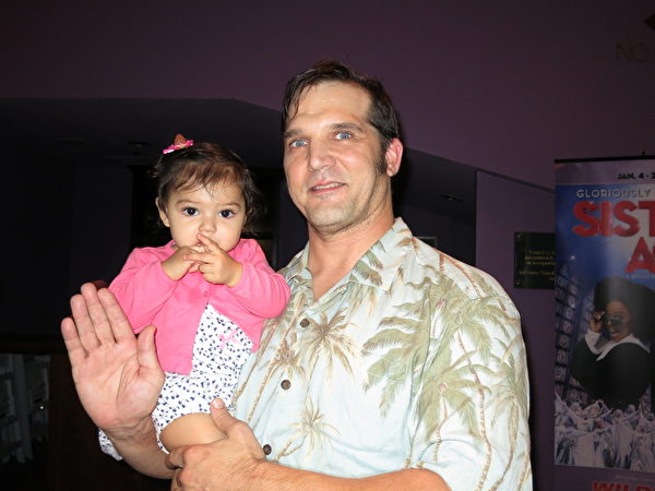 Shawn Hummel是佛州一家公司业主。29日晚，他和太太及两个女儿一起观看了神韵在萨拉索塔的一场演出。图为Shawn Hummel先生和他的小女儿。（林南／大纪元）