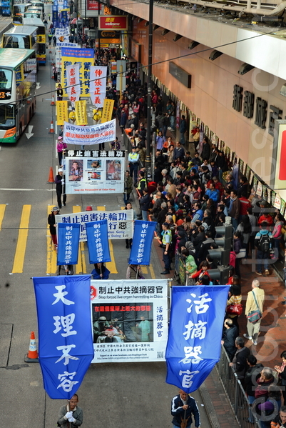 香港和來自各地法輪功學員舉行2015新年大遊行，從北角到中環，途中經過旺區，吸引許多民眾和大陸遊客觀看。（宋祥龍/大紀元）