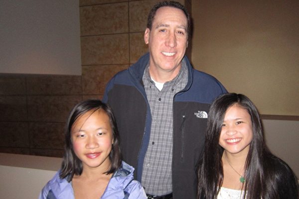 电信公司的会计经理Scott Grunwald带两位领养自中国的可爱女儿Bailey和Zoe来看神韵。（汉民/大纪元）