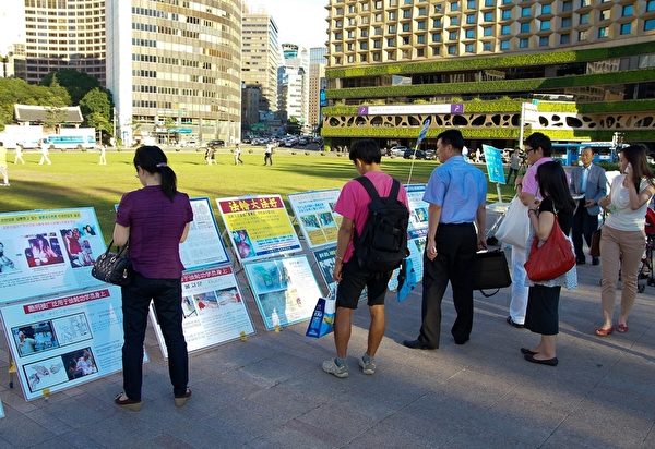 2011年7月20日下午，各国游客在观看韩国法轮功学员在首尔广场展出的真相展板。（摄影：金国焕/大纪元）