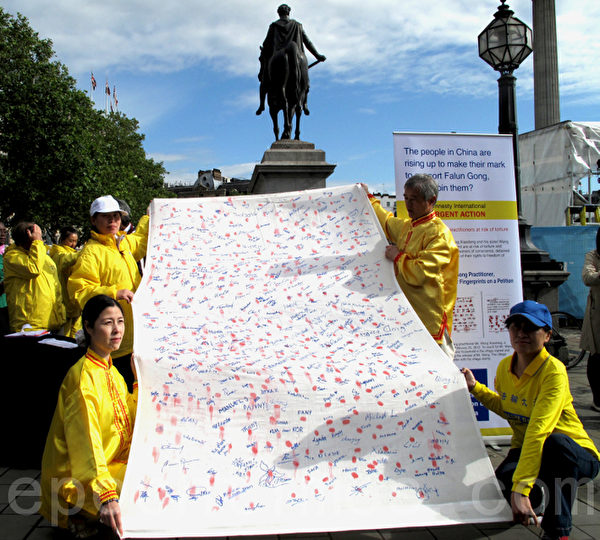 2012年7月21日，來自世界各地的人們簽名、按手印支持制止中共迫害法輪功。（霄鳴/大紀元）                              