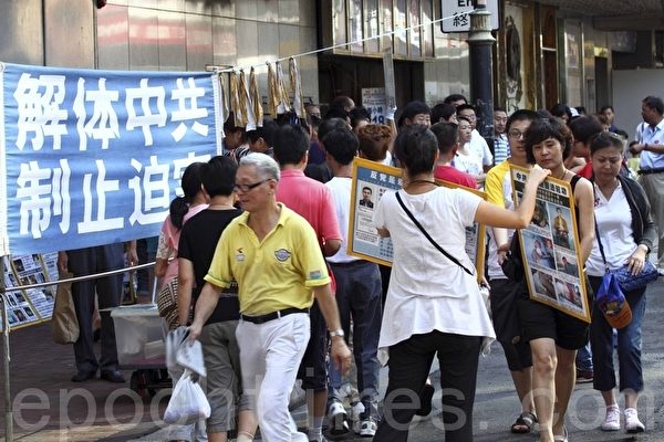 香港法輪功學員手持展板向來往民眾講述法輪功真相。（潘在殊/大紀元）