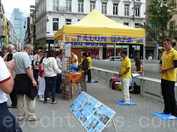 2014年7月19日，比利時法輪功學員在佈魯塞爾摩肩接踵的商業步行街口進行法輪功功法演示、講法輪功真相的活動。（欣然／大紀元）
