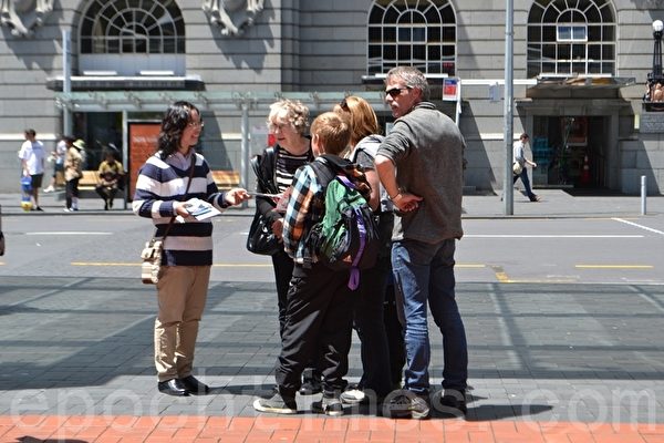 2014年11月8日中午，新西蘭法輪功學員在奧克蘭市中心舉辦反酷刑展示，譴責中共活摘法輪功學員器官牟利的暴行。法輪功學員向民衆講真相。(張莉莉/大紀元)