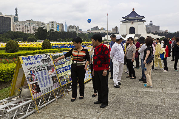 法轮功学员在台北自由广场举行排字弘法讲真相活动，来往民众驻足了解法轮功真相。（王嘉益/大纪元）