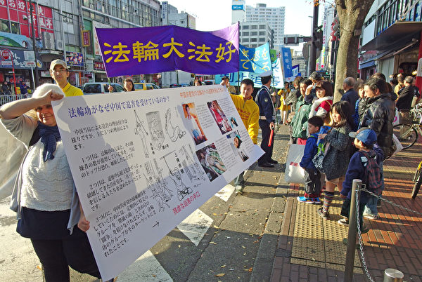 2014年11月23日，來自日本各地的部分法輪功學員在橫濱市舉行紀念《九評》傳播10周年遊行，並呼籲共同制止中共迫害法輪功的罪行。（張本真/大紀元）