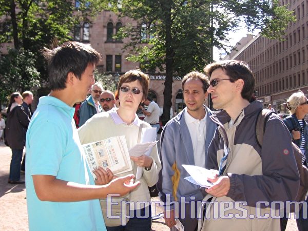 2007年8月21日，法輪功學員向芬蘭遊客，講述法輪功被迫害真相。（姜敏/大紀元）
