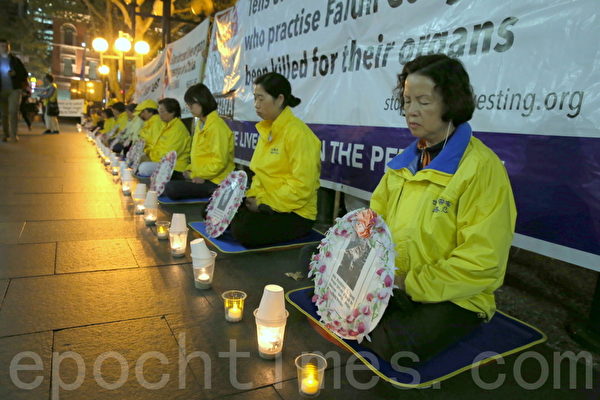 部份澳洲紐省法輪功修煉團體的成員在悉尼市中心的喬治街（George St）舉行燭光集會。（摄影何蔚/大纪元）