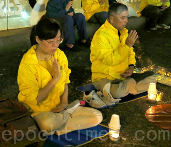 部份澳洲紐省法輪功修煉團體的成員在悉尼市中心的喬治街（George St）舉行燭光集會。（摄影何蔚/大纪元）