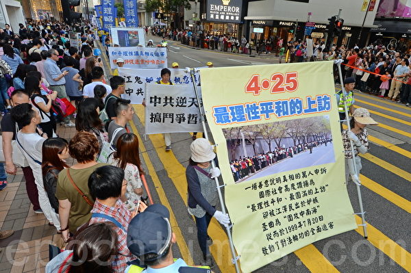 香港法轮功学员25日在长沙湾发起“四二五”16周年反迫害集会游行，浩荡的游行队伍经过闹区，吸引许多民众和大陆游客观看。（宋祥龙/大纪元）