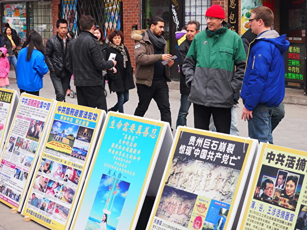2015年4月25日，蒙特利尔法轮功学员在唐人街中山公园纪念“4·25”法轮功和平上访16周年，路人驻足了解真相。（Nathalie Dieul/大纪元）