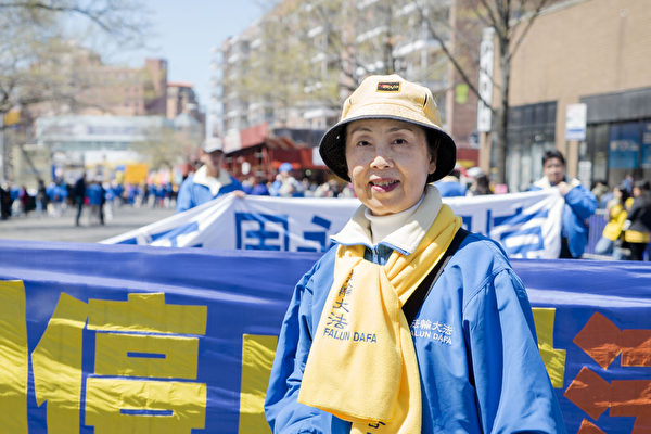 2015年4月25日，约两千名法轮功学员在纽约法拉盛举行大游行和集会。在活动中，法轮功学员闫女士向大纪元记者表示，现在愿意接听真相广播录音的中国人越来越多了。（摄影：谢东延/大纪元）