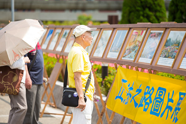 台北部分法轮大法学员约千余位，5月3日在国父纪念馆前广场举办“庆祝513世界法轮大法日”活动。图为游客观看正法之路图片展。（陈柏州/大纪元）