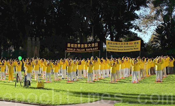 身著黃色衣服的法輪功修煉人在悉尼市中心的海德公園進行集體晨練。（摄影；何蔚/大纪元）