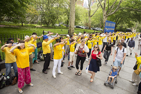 2015年5月12日中午，来自世界各地的法轮功学员到达纽约参加“世界法轮大法日”系列庆祝活动。部分法轮功学员在纽约市政厅门外炼功和派发真相传单。（戴兵/大纪元）