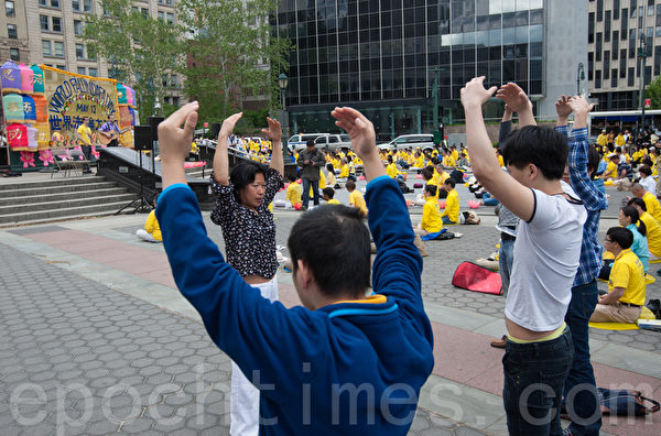 5月13日，法輪功學員紐約富利廣場（Foley Square）煉功。煉功的祥和場面，吸引路人在現場學動作。（馬有志／大紀元）