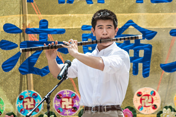 5月13日，法輪功學員在紐約富利廣場演出慶祝第16屆「世界法輪大法日」。圖為加州飛天藝術學校的高橋在演奏笛子獨奏。（馬有志／大紀元）