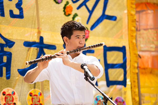 5月13日，法轮功学员在纽约富利广场演出庆祝第16届“世界法轮大法日”。图为加州飞天艺术学校的高桥在演奏笛子独奏。（戴兵／大纪元）