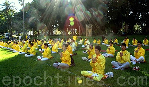 身着黄色衣服的法轮功学员在悉尼市中心的海德公园进行集体晨练。（摄影；何蔚/大纪元）
