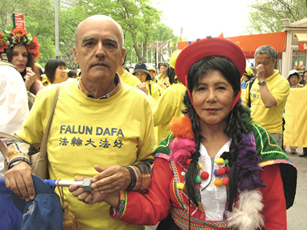 2015年5月15日，加入世界法轮大法日游行“各族裔服饰展示”方阵的秘鲁法轮功学员胡里奥（左）与朱迪斯。（张小清/大纪元）