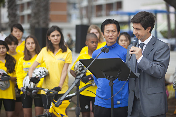 5月31日，部分“骑向自由”(Ride to Freedom) 少年单车队骑手汇聚在洛杉矶旅游胜地圣莫尼卡码头，表达他们希望通过骑单车呼吁全世界关注中共对法轮功的迫害的心声。主持人Albert Roman（右）宣读美国众议院国会议员Lowenthal的支持声明 。(季媛/大纪元) 