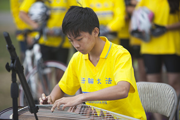 “骑向自由”(Ride to Freedom) 少年单车队骑手在集会现场表演古琴。（季媛/大纪元）
