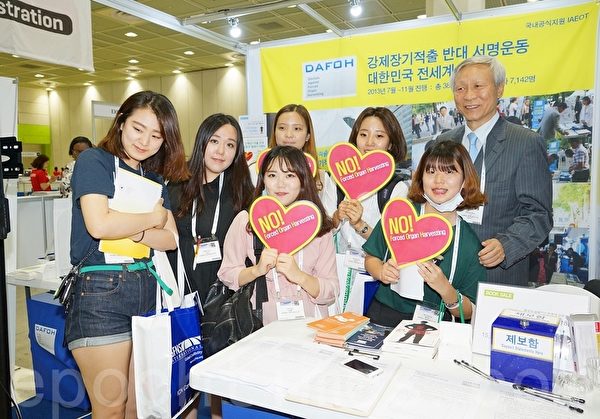 2015世界護士大會6月19～23日在韓國首爾國際會展中心（Ceox）舉行。來自世界各國的與會者手舉反對強摘器官的標籤攝影留念。（金國煥/大紀元）