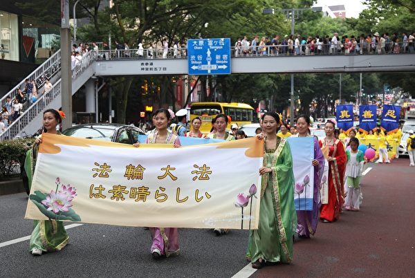 2014年7月13日，日本法輪功學員在東京都舉辦反迫害遊行活動，扮成唐裝仕女的學員手持日文「法輪大法好」的橫幅。（李賢珍/大紀元）