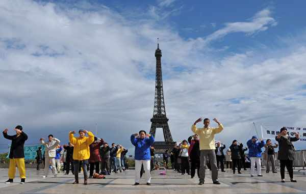 2012年4月24日，法国巴黎法轮功学员在艾菲尔铁塔前炼功，向世人展示法轮功的美好。（本杰明/大纪元） 