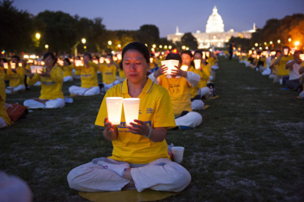 2014年7月17日，美国首都华盛顿，法轮功学员在国会山前的国家广场举行15年和平反迫害烛光夜悼。（戴兵／大纪元）