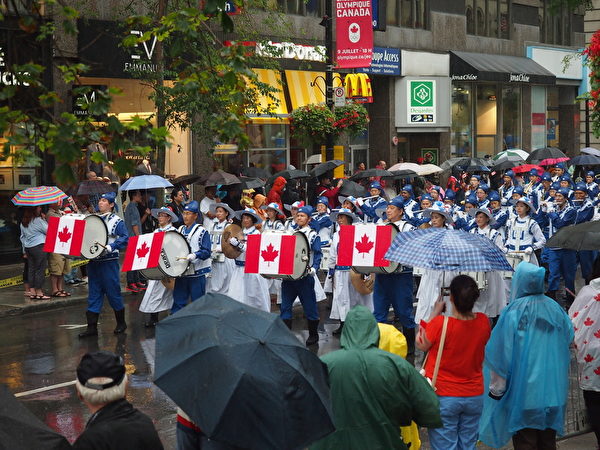 蒙特利尔部分法轮功学员组成的天国乐团以及法轮功方阵，作为国庆游行阵的头阵，参加了今年蒙特利尔的加拿大国庆游行。（Nathalie Dieul / 大纪元）