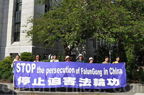 数位法轮功学员在温哥华市政府向到访的广州市市长呼吁停止迫害法轮功。左二为法轮功学员陆群。（唐风/大纪元）
