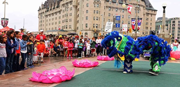 二零一五年加拿大国庆日，法轮功学员表演舞狮，与民众分享节日快乐。（明慧网）