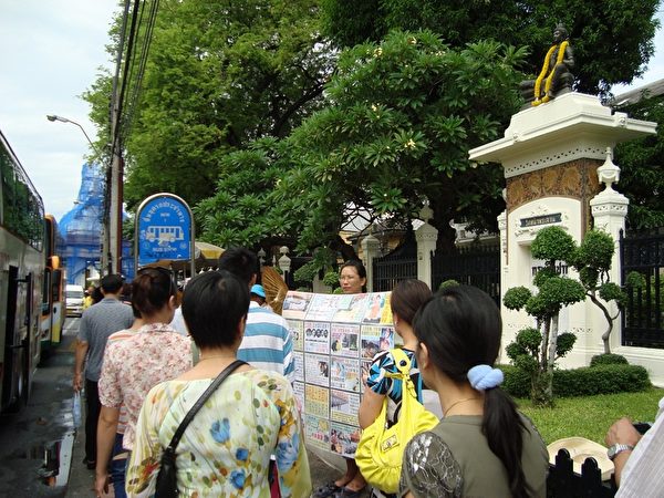 法轮功学员谢冬在泰国曼谷市打着展板向中国大陆游客展示中共迫害法轮功的真相。（受访者提供）