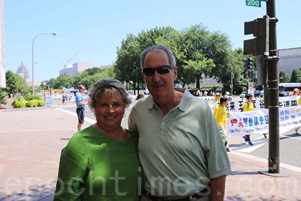 来自得克萨斯州的医生理查德‧布莱克（Richard Black）夫妇在看到游行队伍后，驻足观看，并表示了对法轮功修炼者的支持。（萧桐／大纪元）