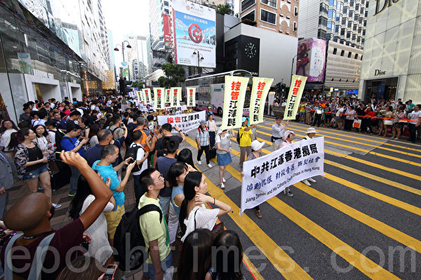 香港法轮功学员7月18日开始一连两天举行纪念7·20活动，首日约700名学员在九龙区闹市举行“控告江泽民”大游行，吸引许多市民及大陆游客的观看。（潘在殊/大纪元）