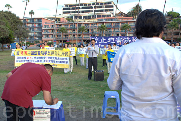 游客在观集会、签名反对活摘器官。（杨婕／大纪元）