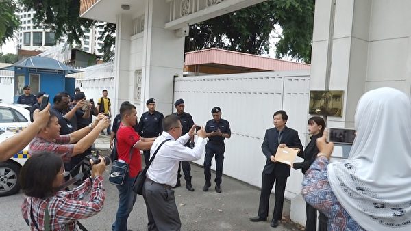 法輪功學員代表到中共駐馬大使館遞交抗議信，引起了許多官員的關注。（新唐人圖片）