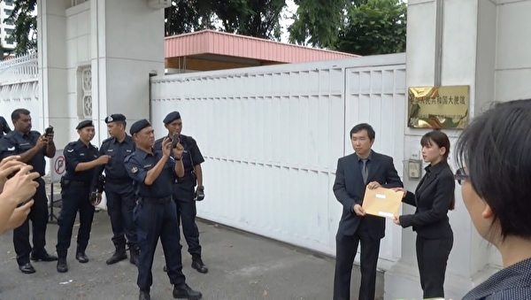 法轮功学员代表到中共驻马大使馆递交抗议信，引起了许多官员的关注。（新唐人图片）