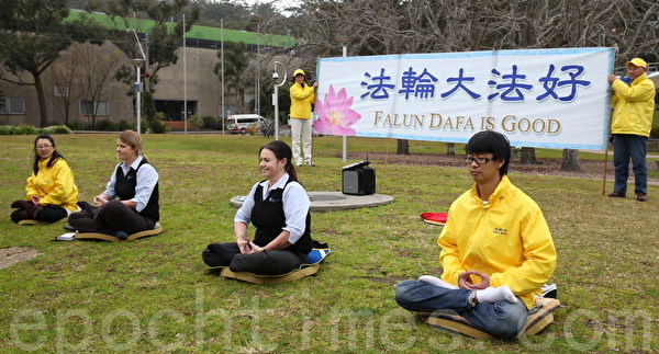 两名在当地工作的年轻女子在午餐时间到公园学习打坐。（摄影：何蔚/大纪元）